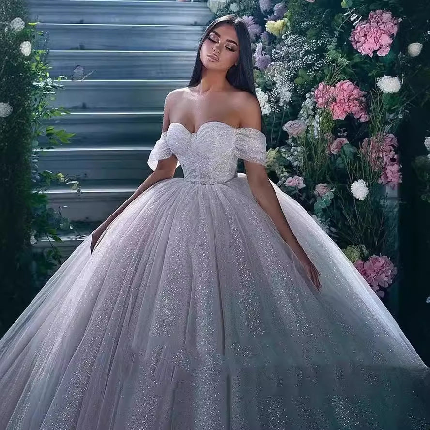 Off-Shoulder White Sequined Ball Gown Wedding Dress with Full Tulle Skirt.
