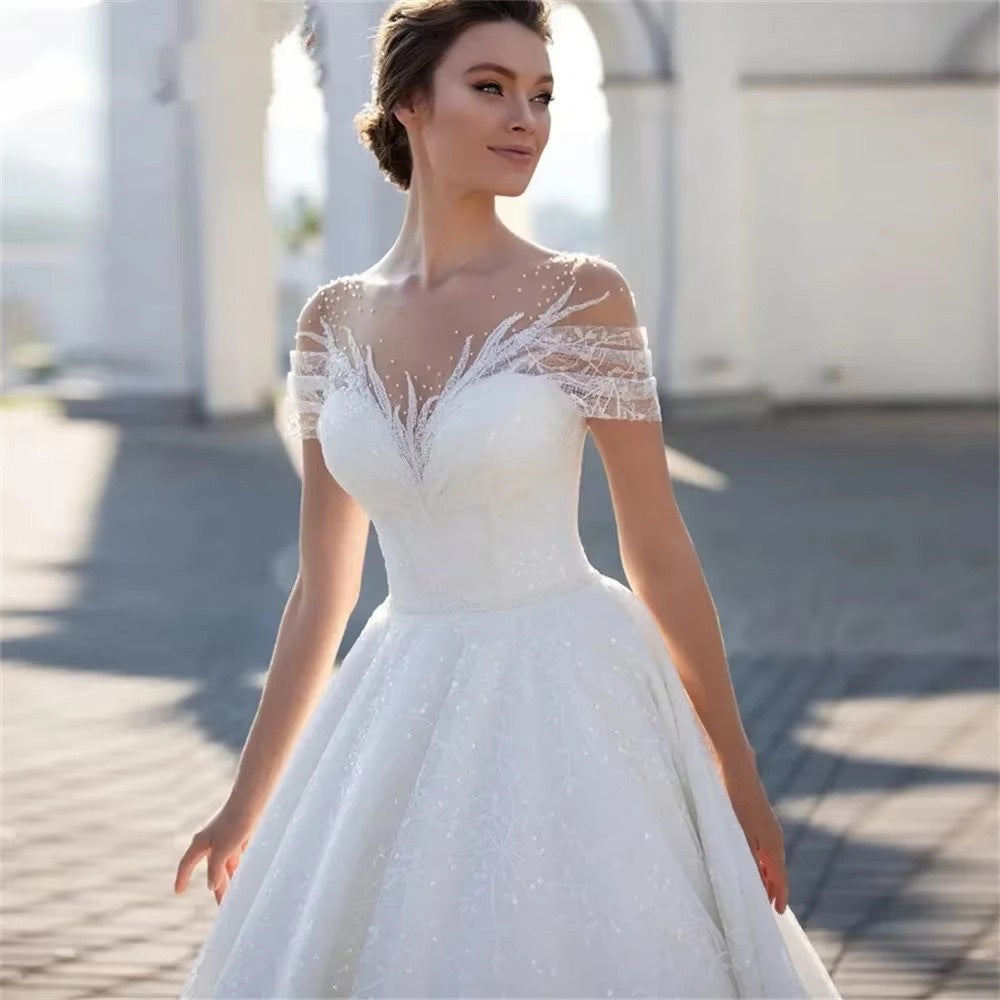Off-Shoulder White Lace Wedding Dress with Train and Veil.